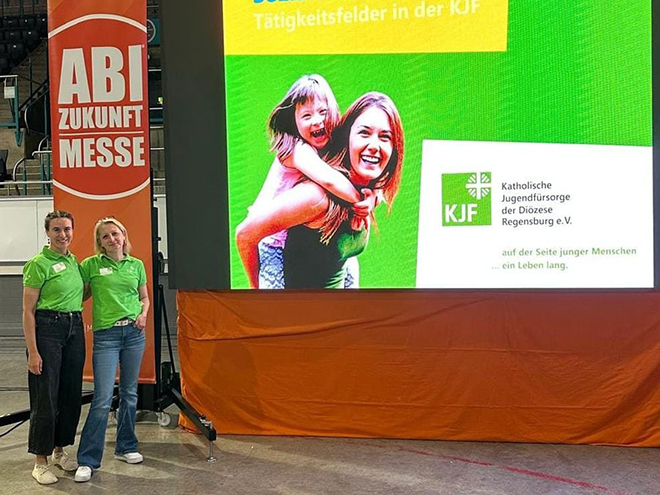 Kolleg*innen der Katholischen Jugendfürsorge, die Werbematerial präsentieren